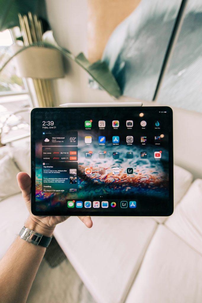 Image vue sur une tablette en main illustrant la vente de tablettes Apple et Samsung